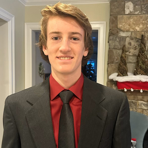 A young man smiling wearing a suit